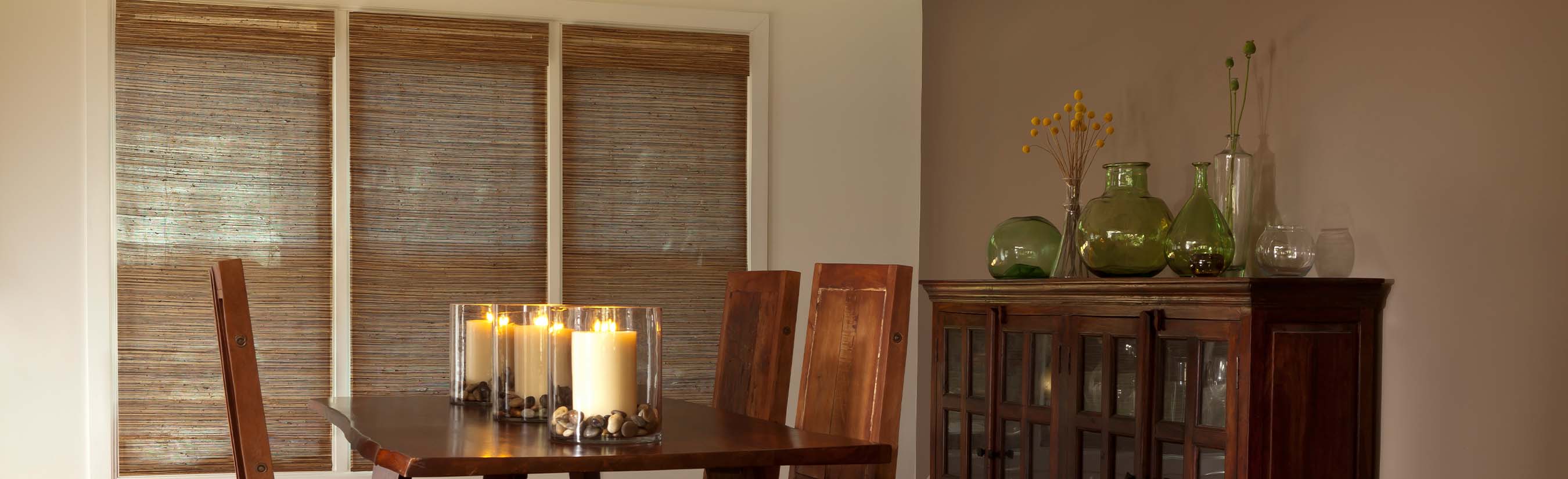 Brown woven shades in a dining room with candlelight.